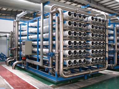 Reverse osmosis water treatment system: membrane housings, pumps and stainless steel pipework on a blue skid frame